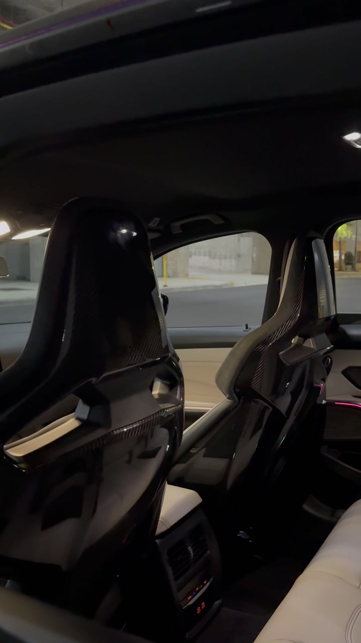 Detailed BMW interior with carbon-fiber bucket seats and cream leather
